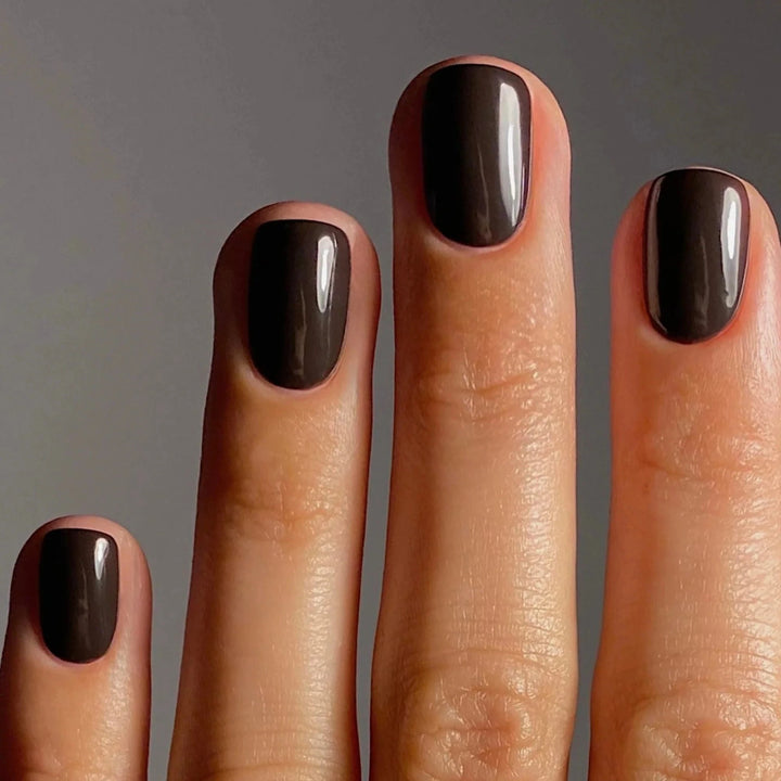 Karolin Van Loon 54 Figue Marron veganer brauner Nagellack mit goldenen Untertönen auf Fingernägeln.