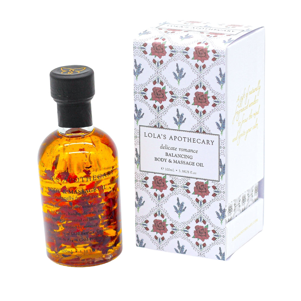 Glasflasche Lola´s Apothecary Body & Massage Öl mit orangerotem Inhalt, daneben die Verpackung.