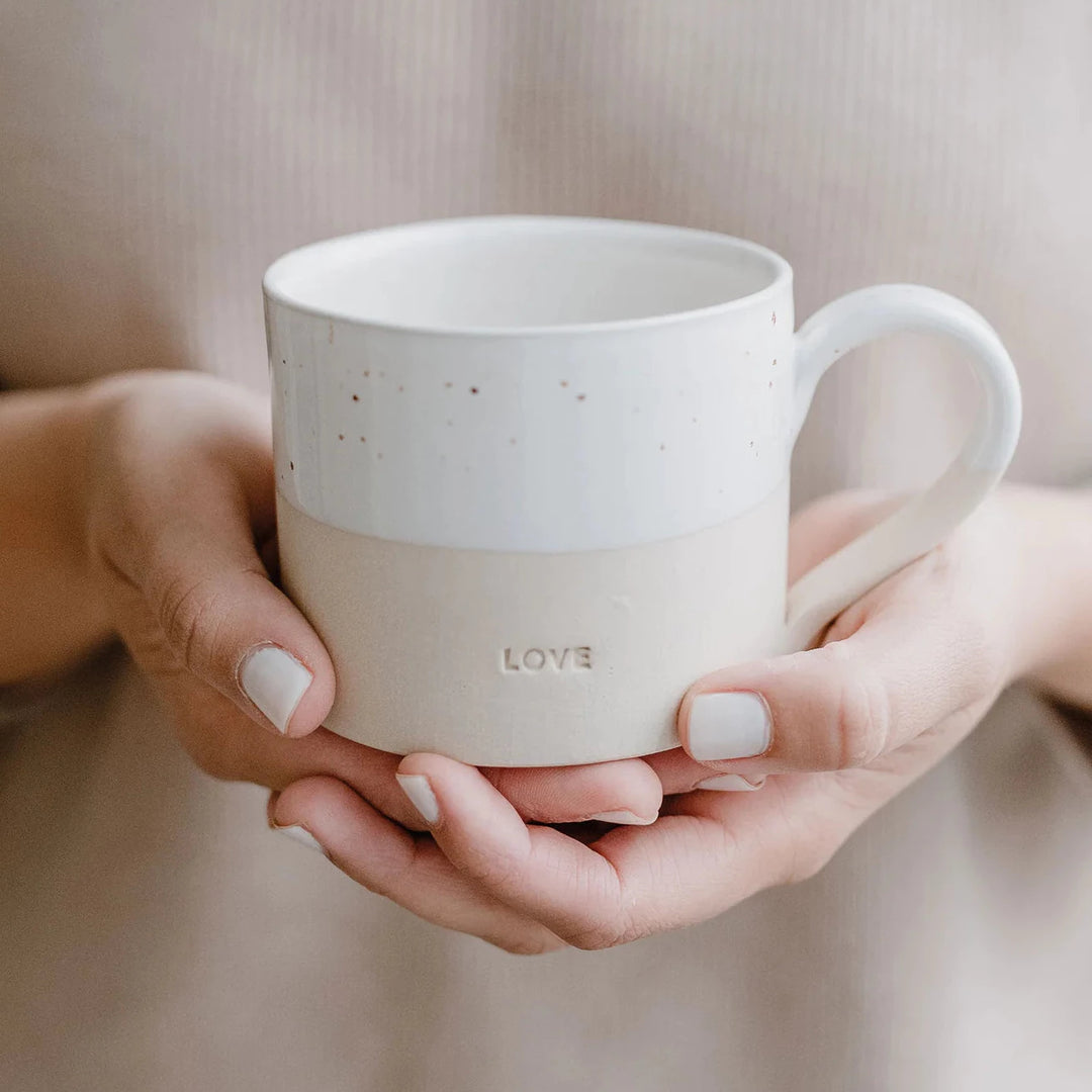 Teetasse "Love" wird von zwei Händen gehalten