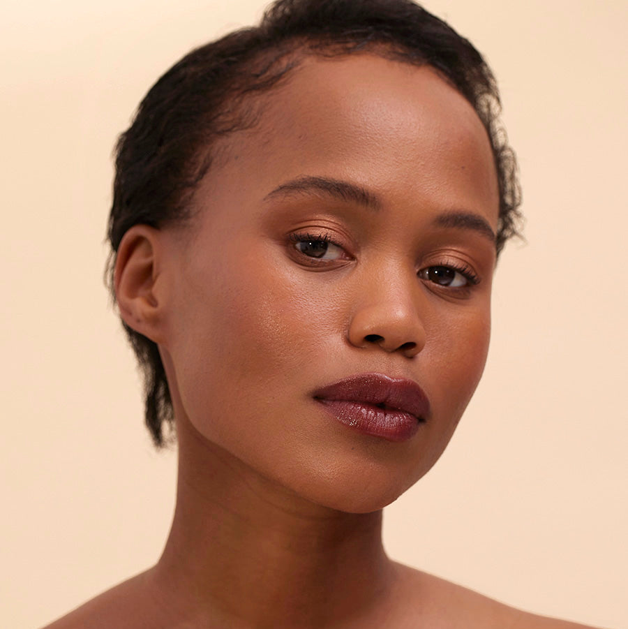 Henné Organics Nightfall Lip Tint auf Lippen mit elegantem, dunklem Rotton
