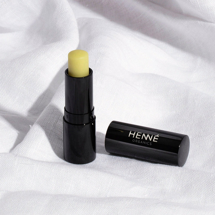 Henné Lip Balm geöffnet, daneben liegt der Deckel, auf weißem Leinentuch.