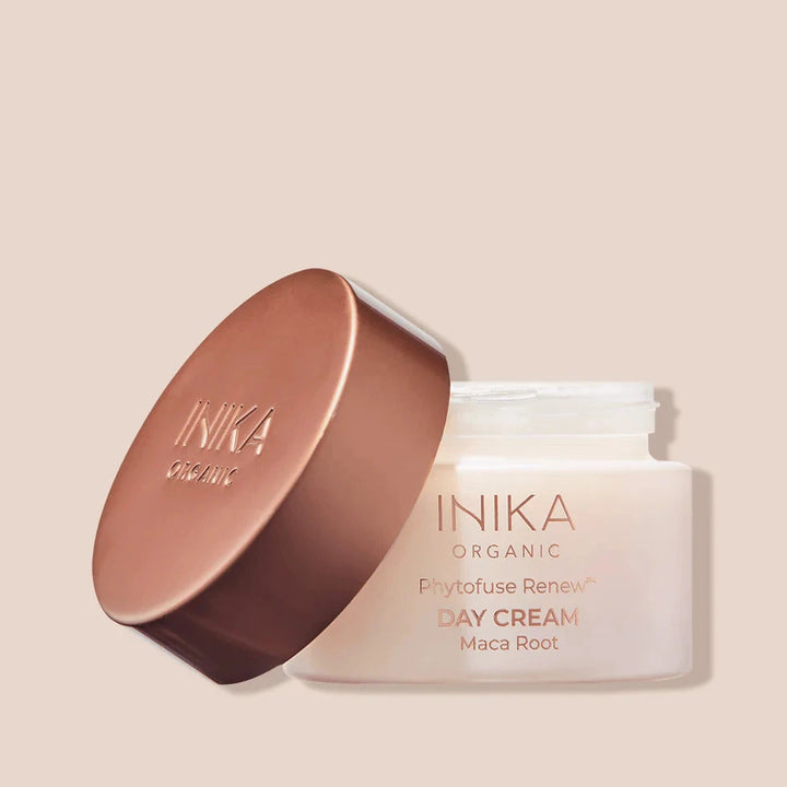 INIKA Phytofuse renew Day Cream in milchigem Tiegel mit bronzefarbenen Deckel auf beigem Hintergrund