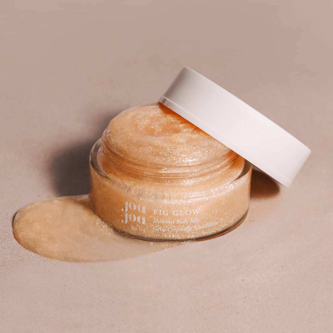 FIG GLOW Shimmer Body Jelly Tiegel  geöffnet mit anliegendem Deckel, glitzerndes Gel auf dem Untergund verschmiert.