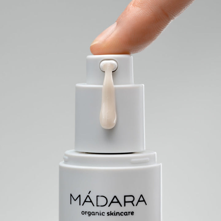 Pumpgefäß von Mádara wird von einem Finger heruntegedrückt und Serum fließt heraus.