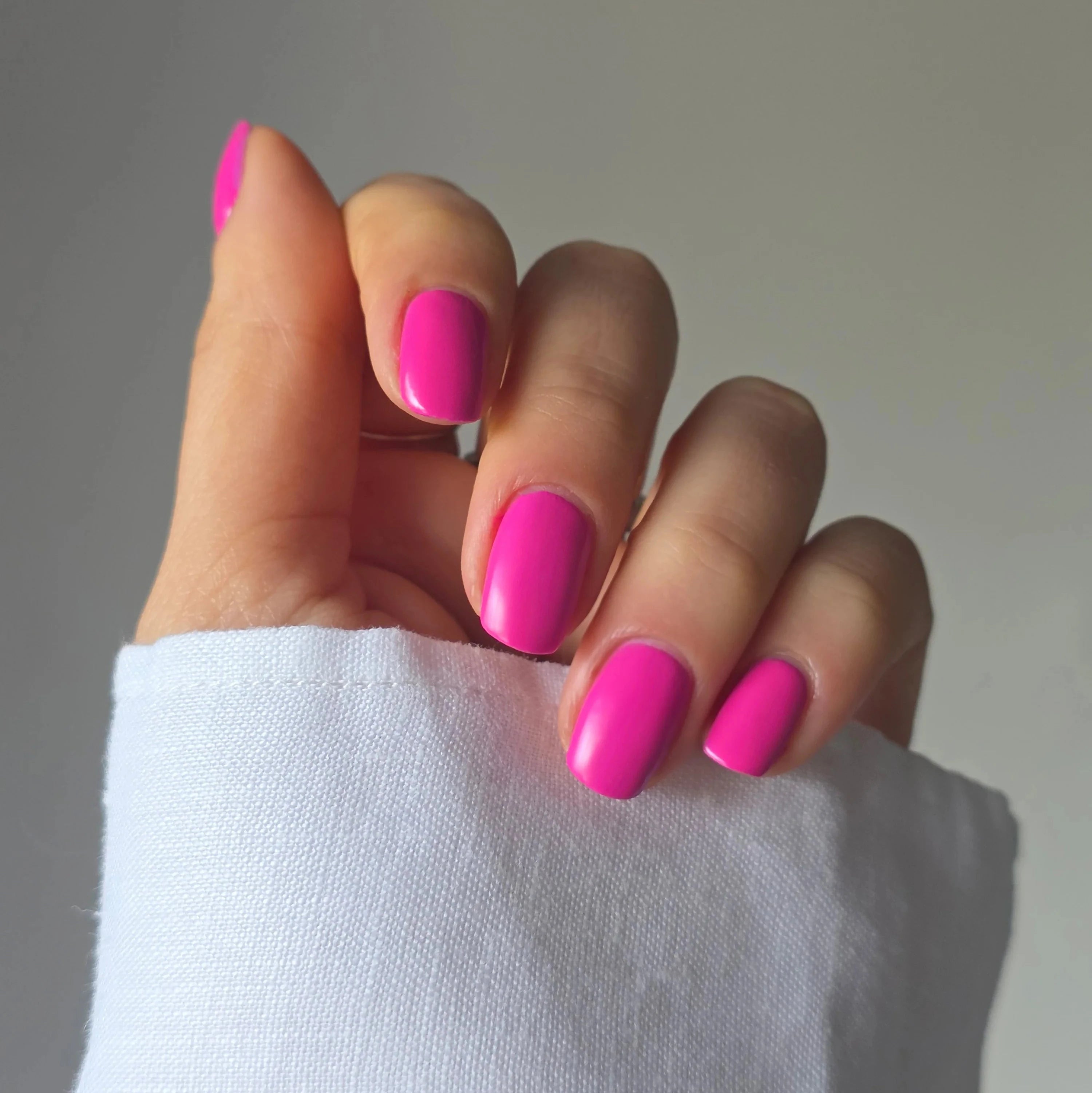 Nailberry Electric Pink auf Fingernägeln präsentiert.