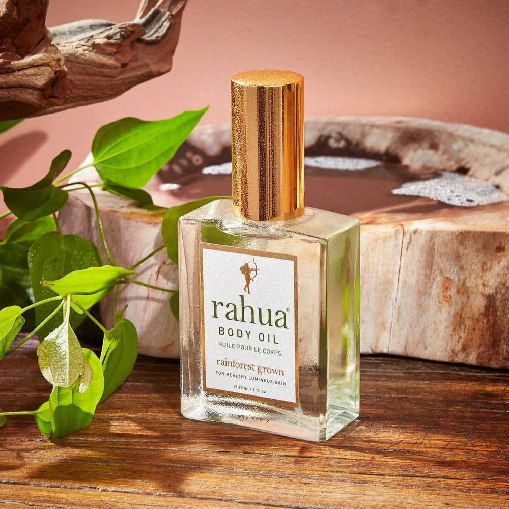 Rahua Body Oil Flasche steht dekorativ auf einem Holztisch.