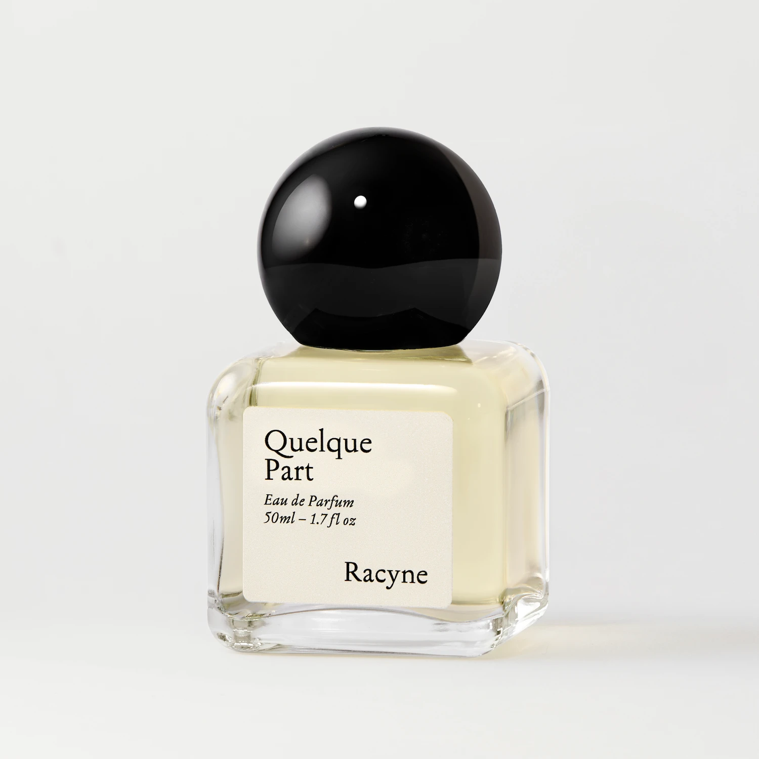 Quelque Part Eau de Parfum von Racyne – minimalistischer Glasflakon mit hellem Frontetikett und rundem dunklem Verschluss
