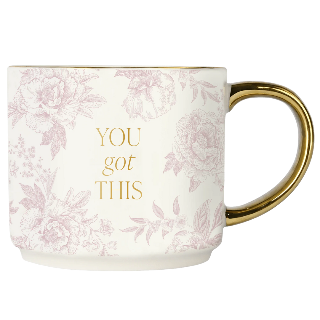 Tasse mit rosa Muster, goldener Aufschrift "YOU got THIS" und goldenem Henkel, vor weißem Hintergrund. North Glow