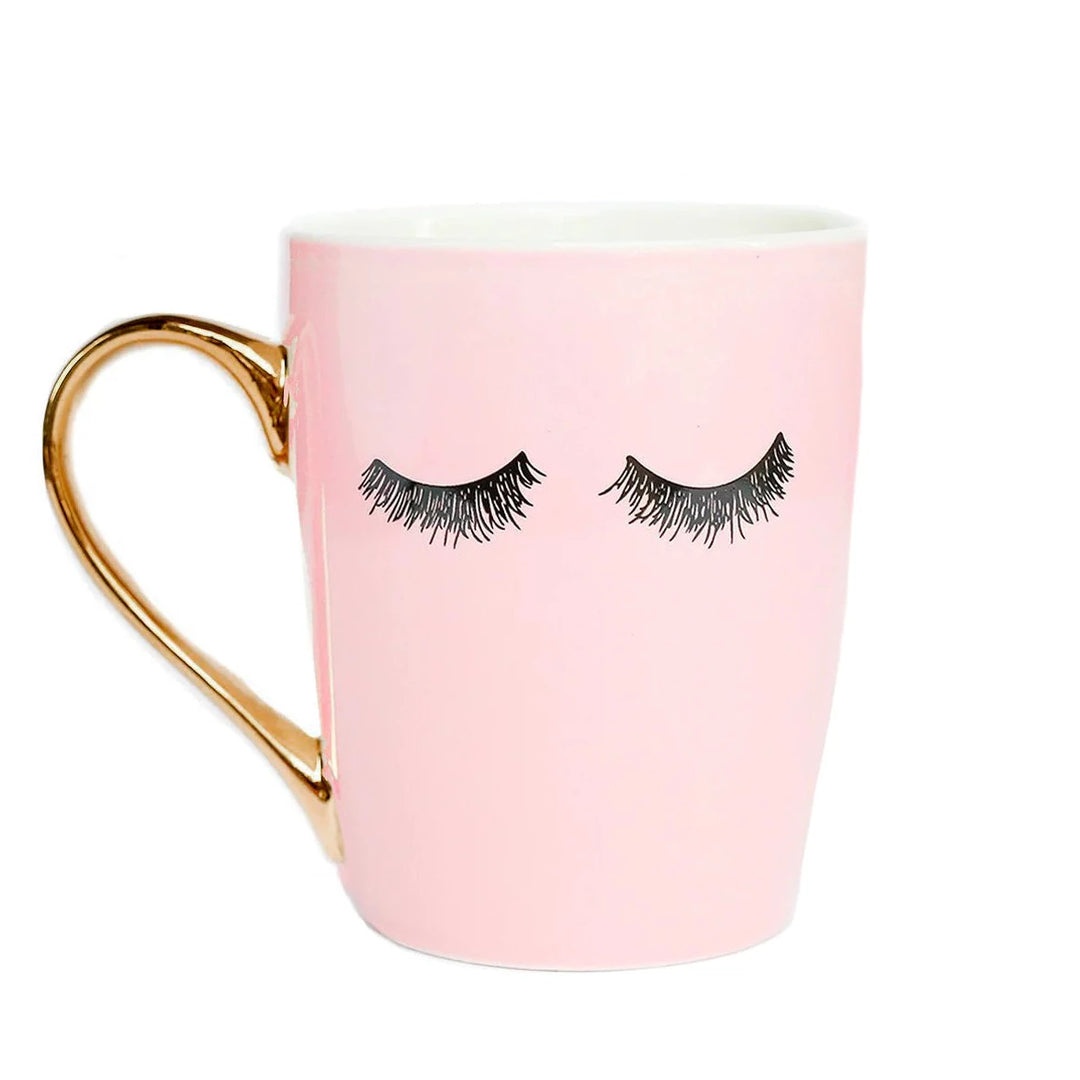 Rosafarbene Kaffeetasse "Pink Eyelashes" mit Wimpernaufdruck und goldenem Henkel vor weißem Hintergund North Glow