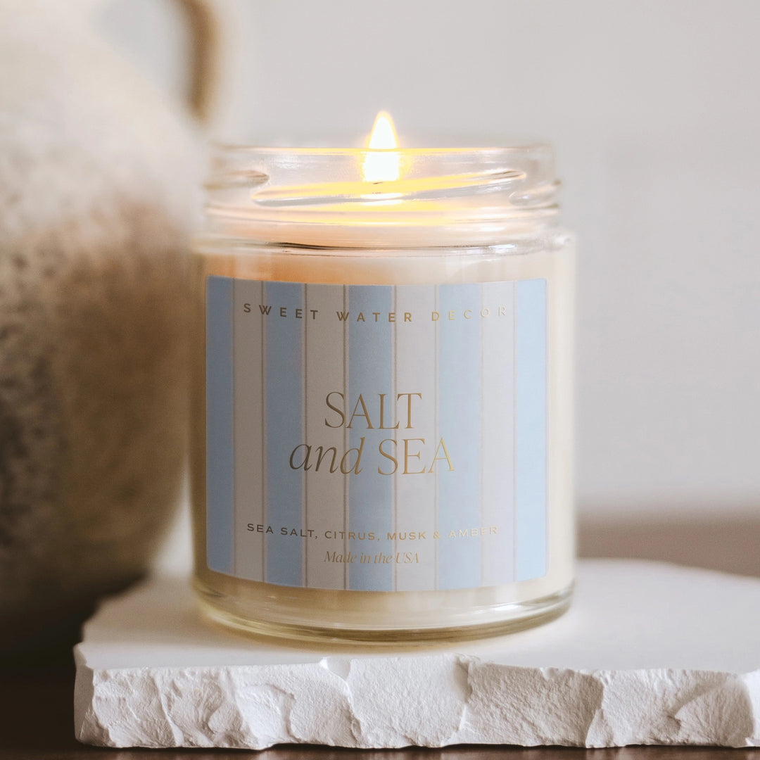 Brennende Sweet Water Decor Duftkerze Salt and Sea im durchsichtigem Glas mit gestreiften Etikett. North Glow