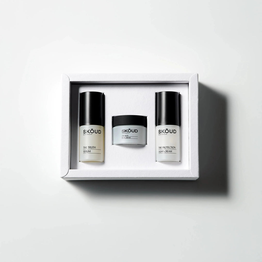 Geöffneter nachhaltiger Karton mit SKŌUD Pflege-Minis – vegane Hautpflege-Essentials North Glow