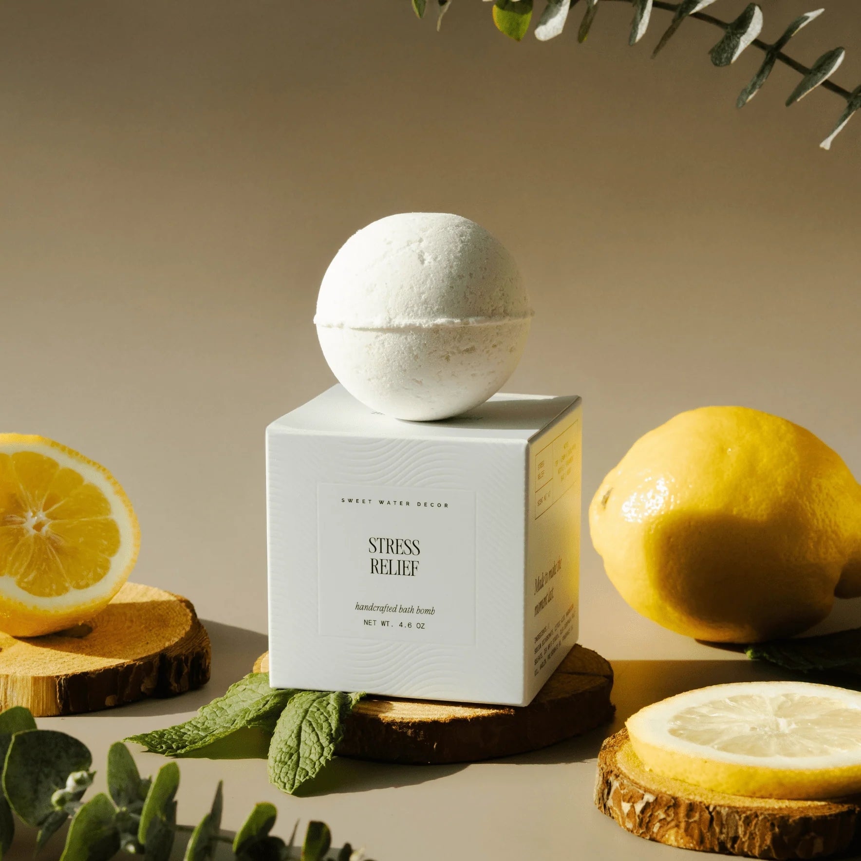 Sweet Water Decor Badebombe Stress Relief neben Zitronen und Minze
