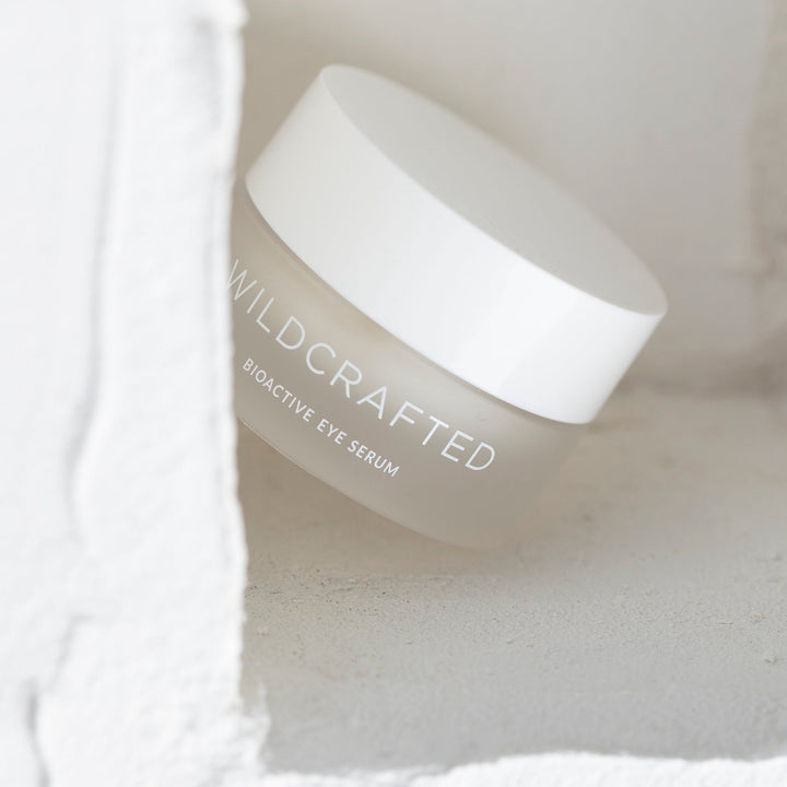 Milchglastiegel mit weißem Deckel Wildcrafted Bioactive Eye Serum vor hellem Hintergrund.