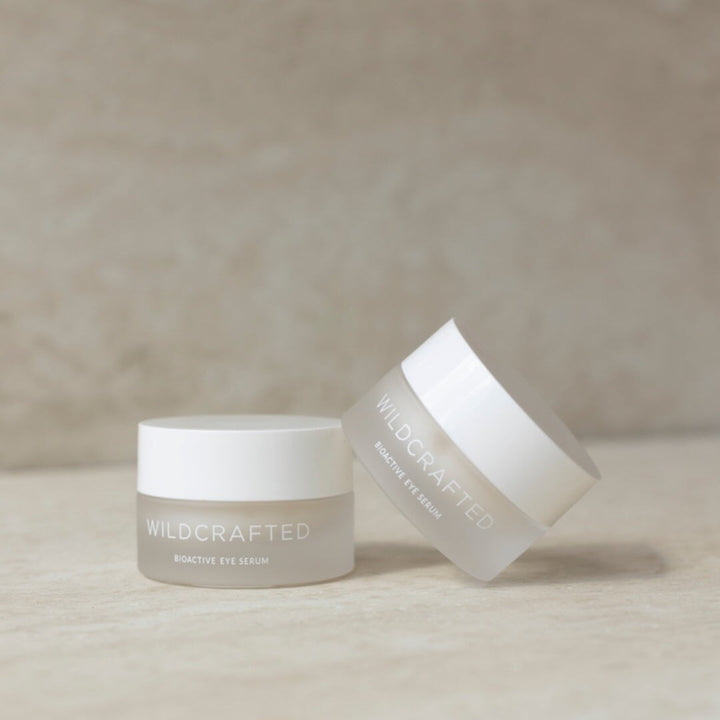 2 Milchglastiegel mit weißem Deckel Wildcrafted Bioactive Eye Serum stehen vor hellem Hintergrund.