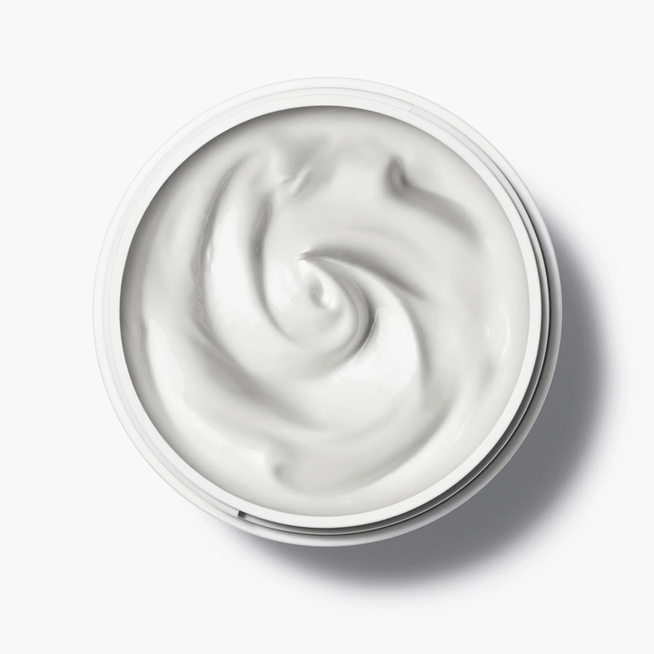 Offener Tiegel der Manasi 7 Botanical Face Cream Furora aus der Vogelperspektive steht auf weißem Untergrund.