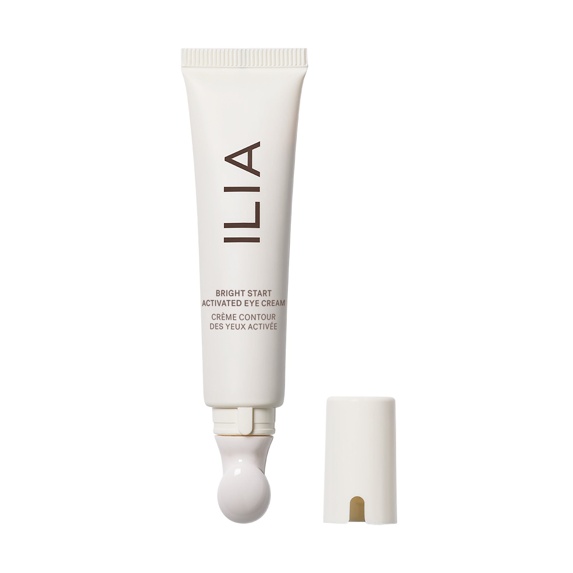 Offene ILIA Bright Start Activated Eye Cream Tube neben Deckel steht vor weißem Hintergrund.