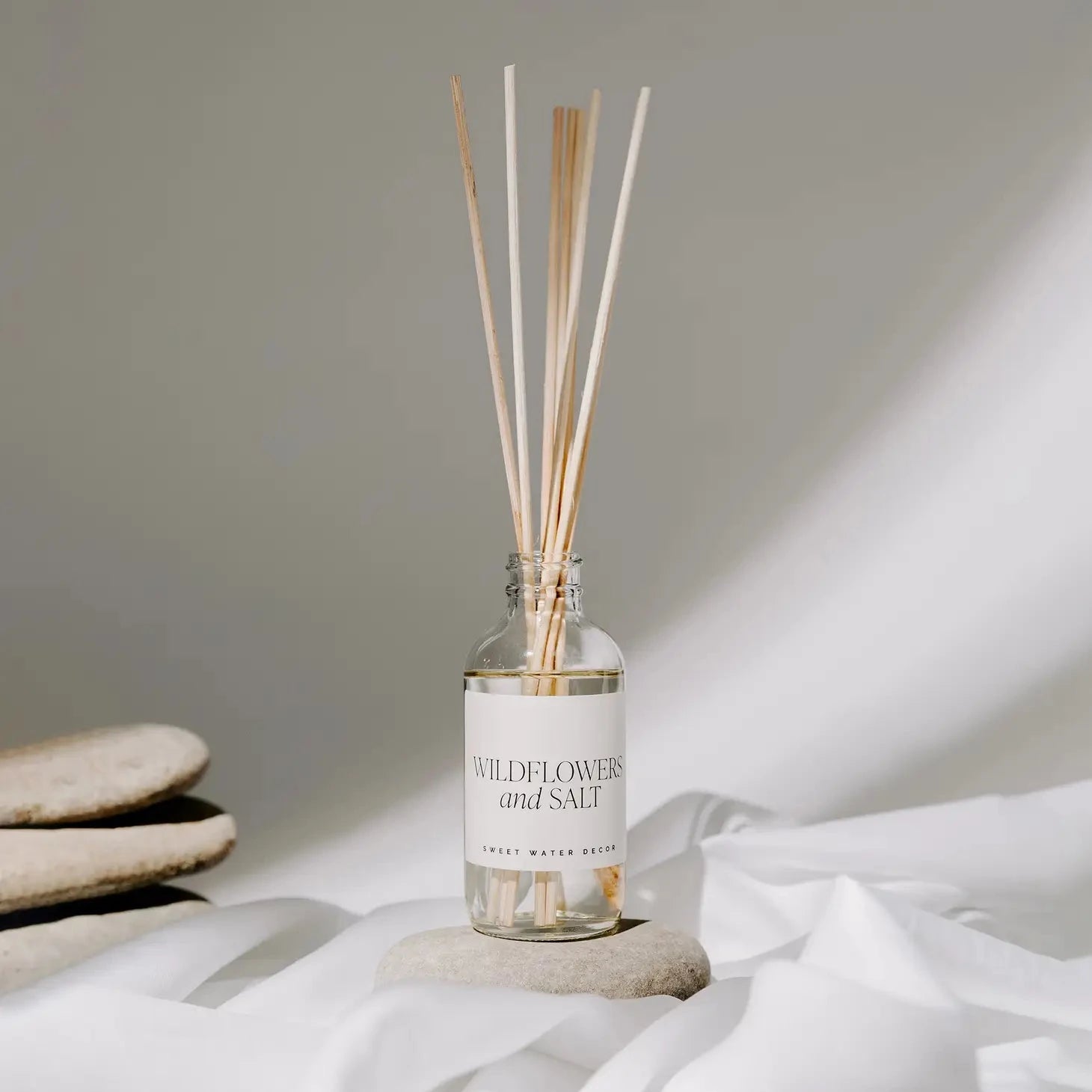 Sweet Water Decor Diffuser Wildflower and Salt Flasche mit Schilfrohrstäbchen und Karton.