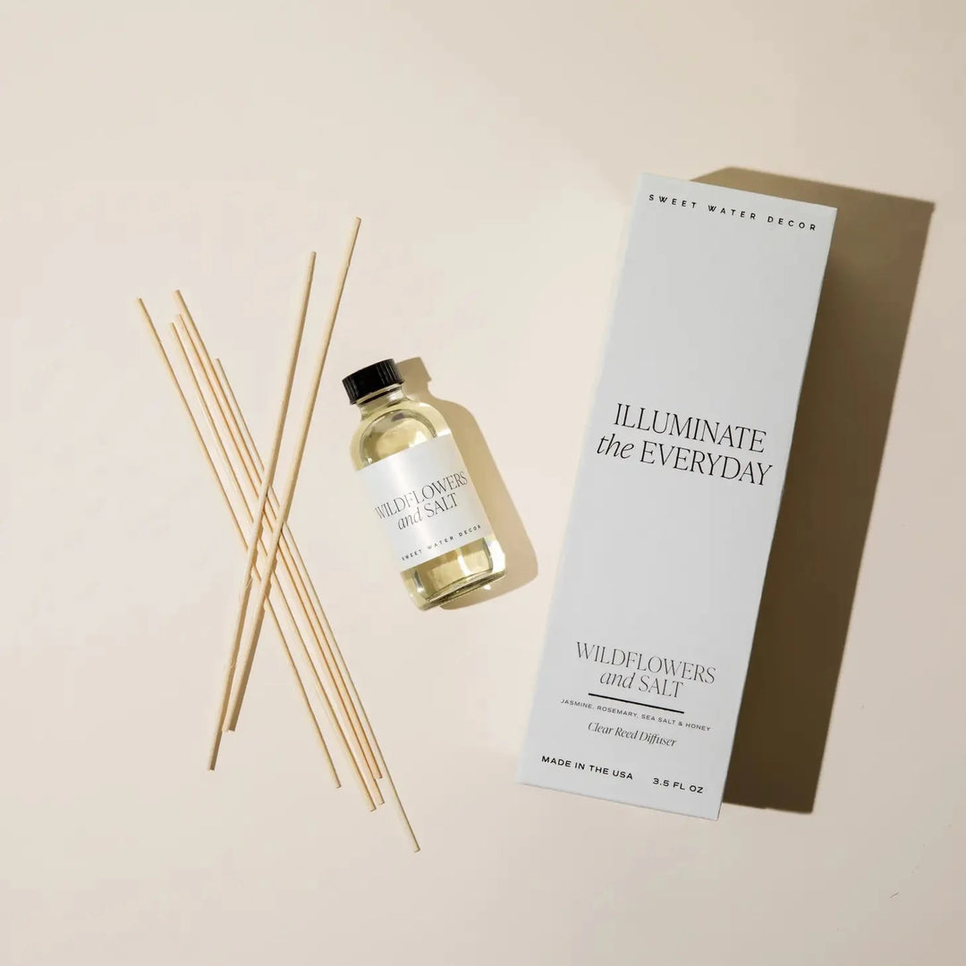 Transparente Flasche Diffuser Wildflowers and Salt von Sweet Water Decor mit Schilfrohrstangen und Verpackung aus der Vogelperspektive. North Glow