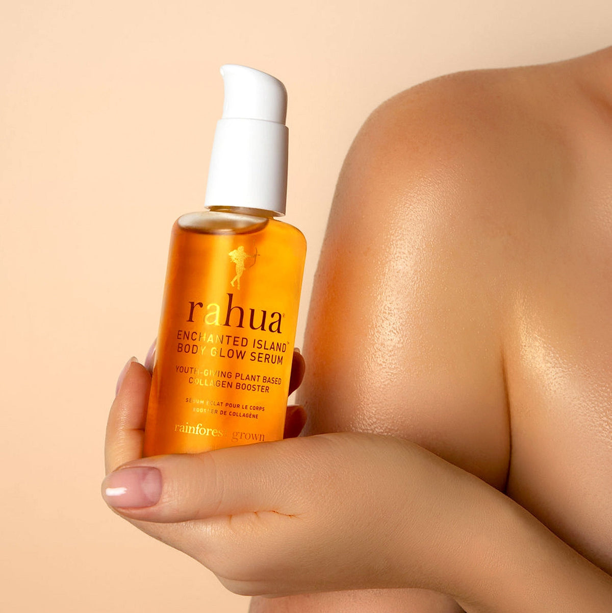 Rahua Enchanted Island Body Glow Serum Flasche gehalten von einer weiblichen Hand.