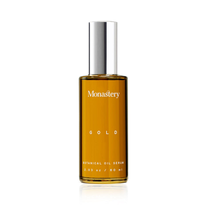 Monastery Gold Serum Glasflasche mit silbernem Deckel vor weißem Hintergrund.