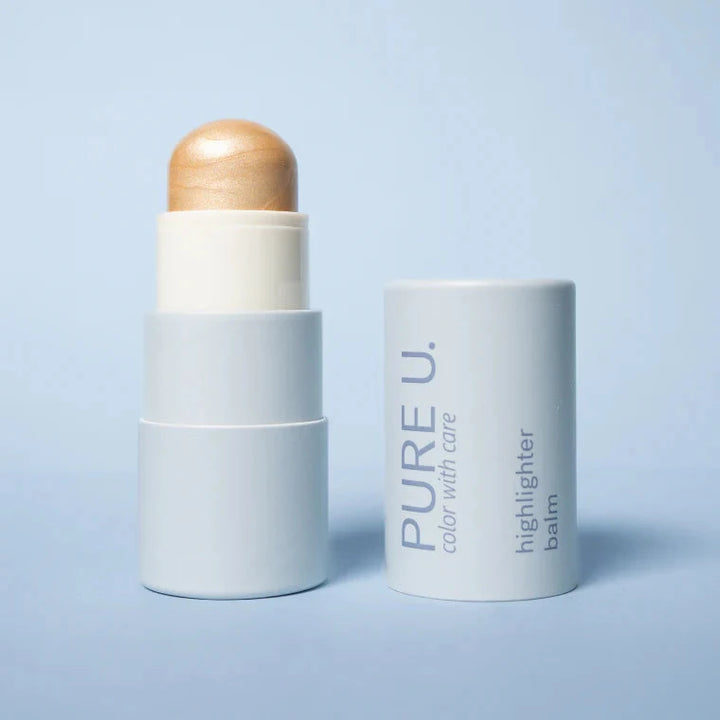 Highlighter Balm von PURE U. Cosmetics geöffnet vor hellblauem Hintergrund.