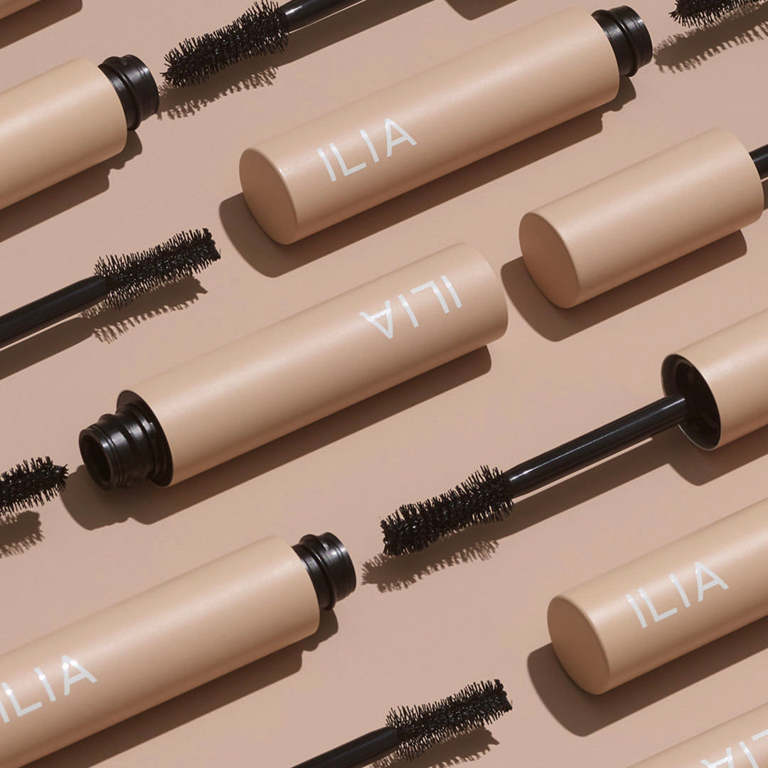 Mehrere ILIA Fullest Voluminizing Mascaras nebeneinander und untereinander aufgereiht.  North Glow