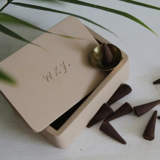 Geöffnete wxy. rose petal Betonbehälter für Räucherkegel mit räucherkegeln ober drauf vor weißem Hintergrund. North Glow