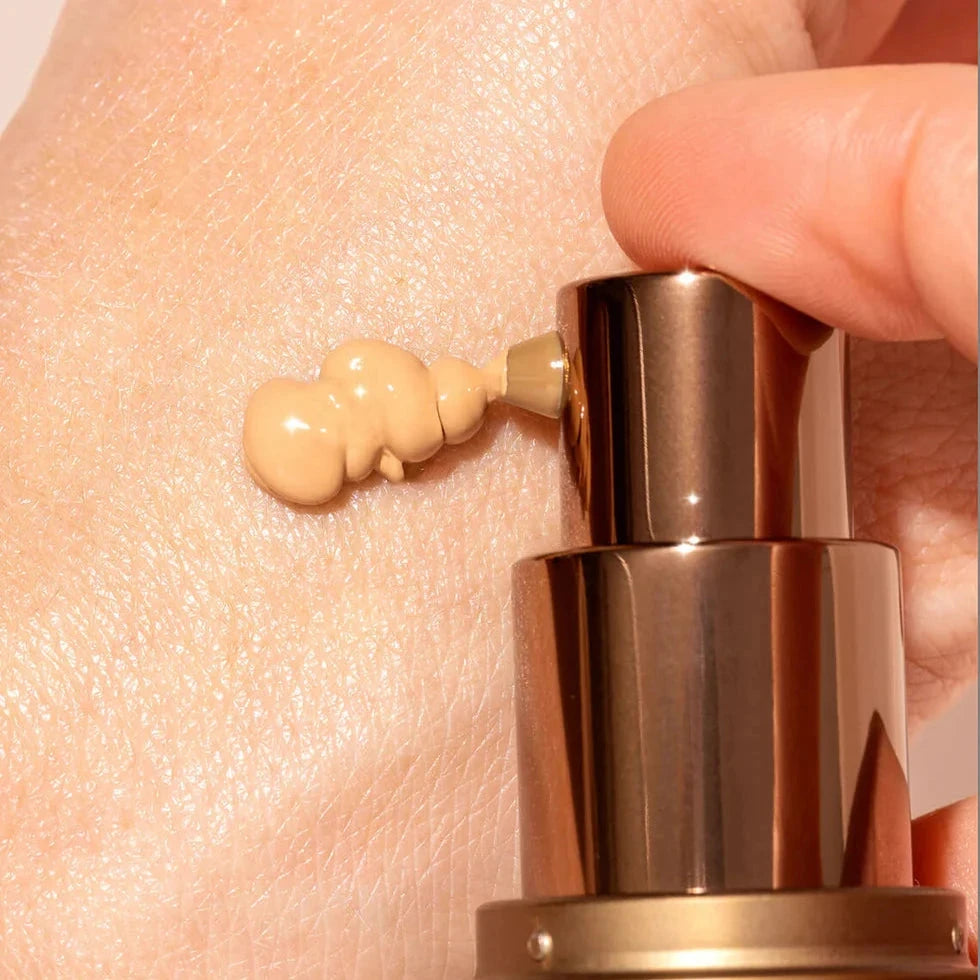 Ein Pumpstoße BB Cream von IKIKA wird auf einer Hand gepumpt.