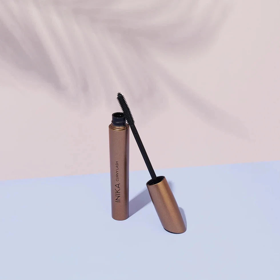 INIKA Curvy Lash Mascara geöffnet mit angelehnter Bürste. North Glow