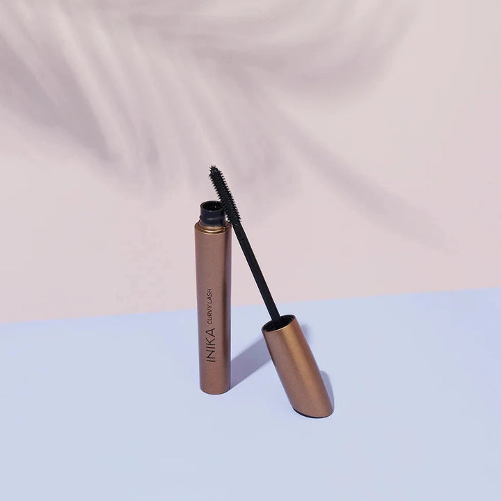 INIKA Curvy Lash Mascara geöffnet mit angelehnter Bürste.