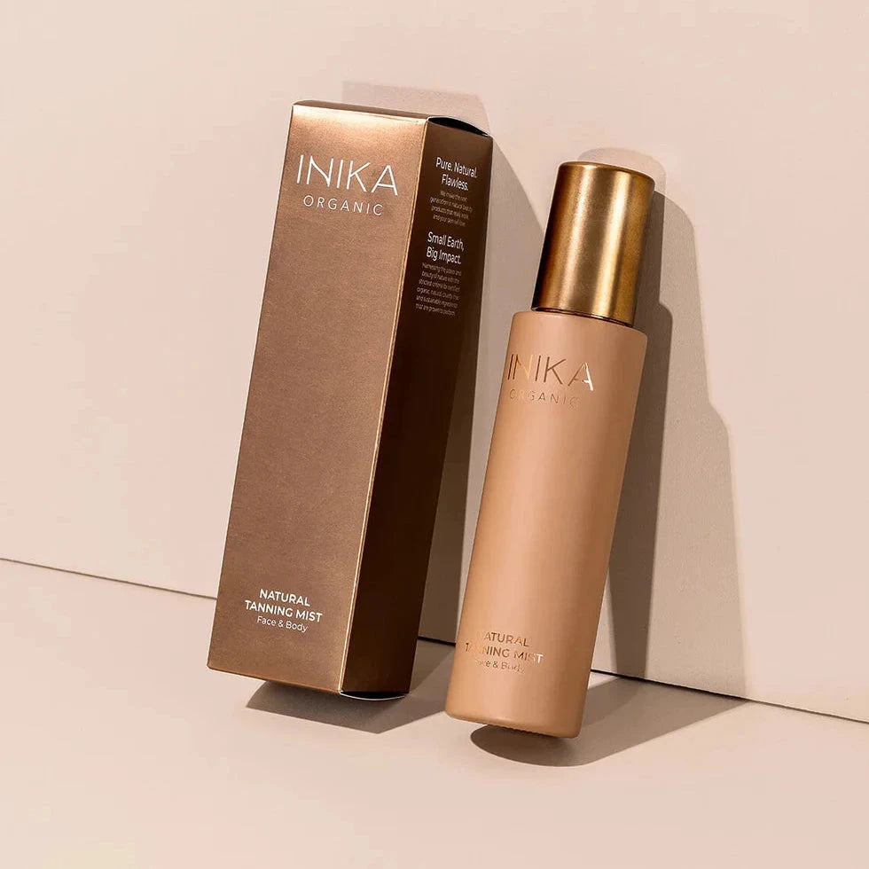 Natural Tanning Mist Pumpflasche und die Verpackung lehnen nebeneinander an einer Wand.