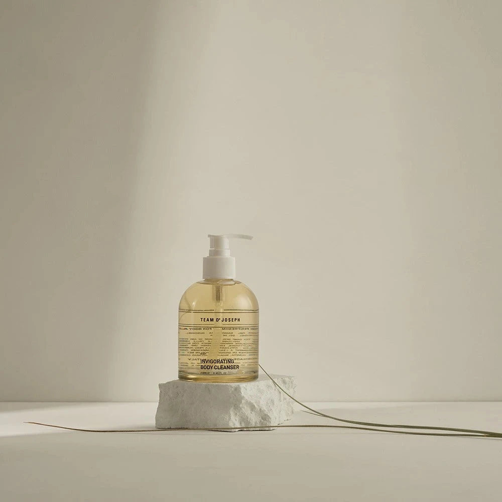 TEAM DR JOSEPH Invigorating Body Cleanser als Moodbild – stilvoll inszeniert auf natürlichem Stein für einen cleanen, minimalistischen Look.