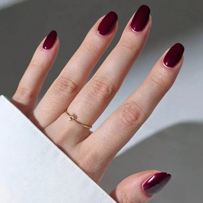 Hand mit Nagellack Kirsch Kiss von Nailberry.