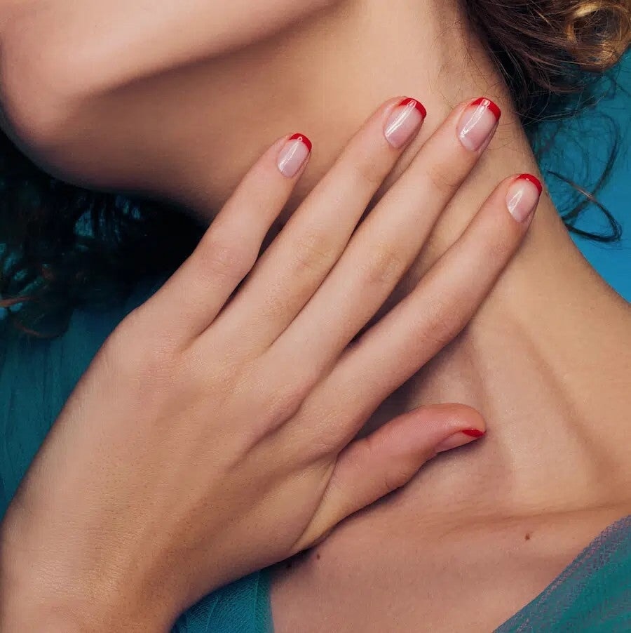 Le Rouge Francais La Base Top Coat Anwendungsbeispiel an einer Frauenhand mit roten French Tips.