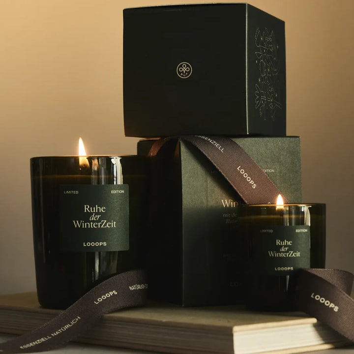 Winterliche Duftkerze Limited Edition Ruhe der Winterzeit von Looops in 2 Größen mit Verpackungen festlich dekoriert.