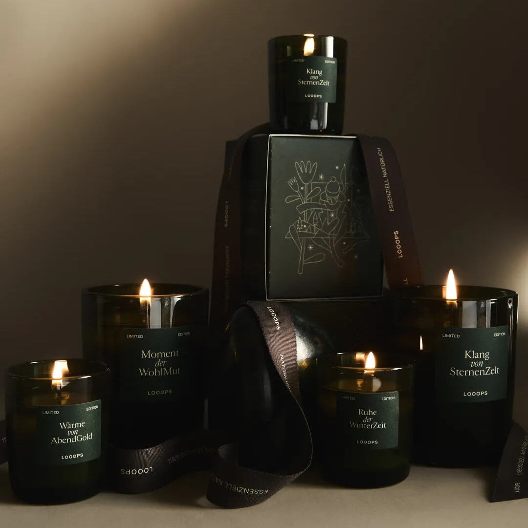Brennende Duftkerzen der Limited Edition  von Looops in 2 Größen mit Verpackungen festlich dekoriert. North Glow