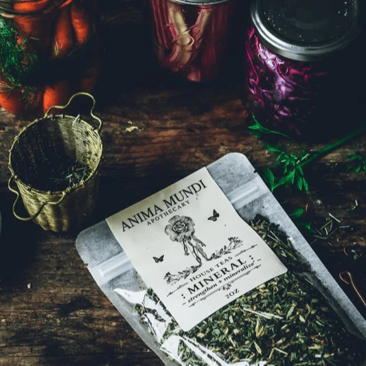 Transparente Produkttüte von Anima Mundi Mineralize zwischen getrockneten Kräutern