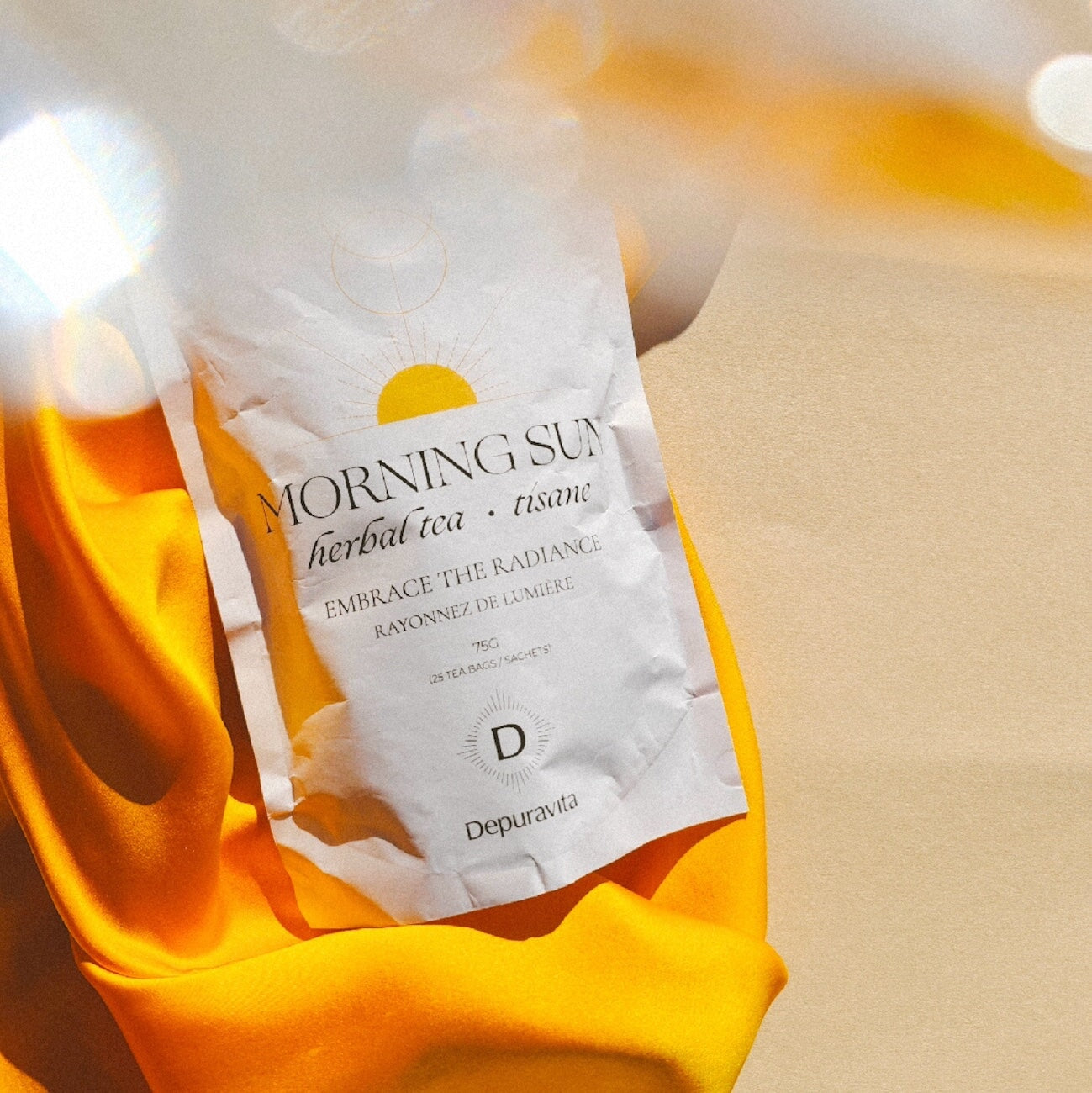 Depuravita Morning Sun Tee liegt auf einem orangefarbenen Tuch.