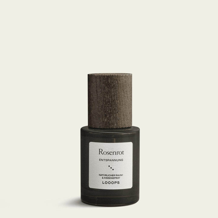 Flasche Rosenrot Raum- und Kissenspray von Looops mit Holzdeckel steht vor weißem Hintergrund.