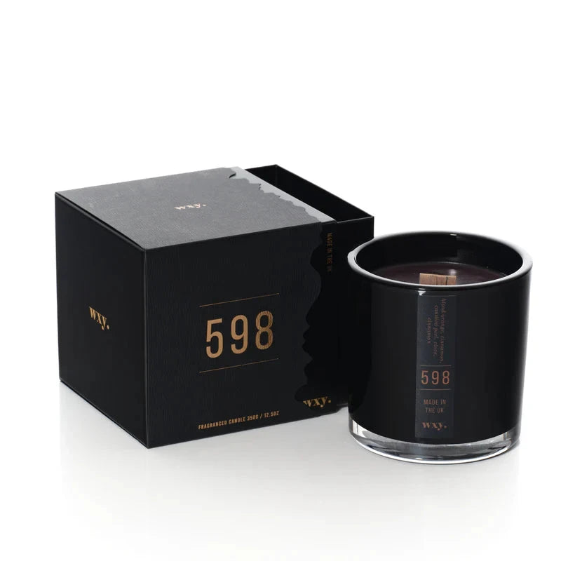 Schwarze wxy. Kerze mit Verpackung vor weißem Hintergrund. North Glow