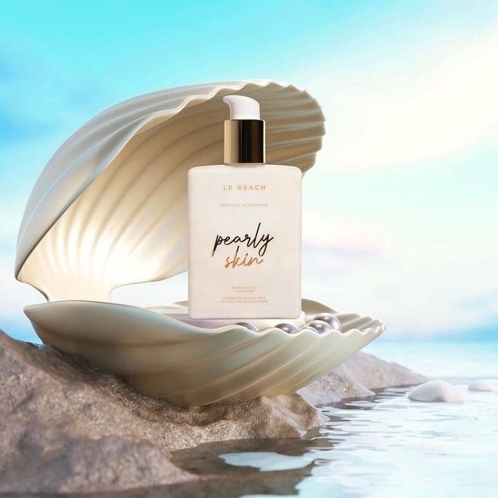 Le Beach Pearly Skin Pumpflasche steht in einer Muschel am Meer.