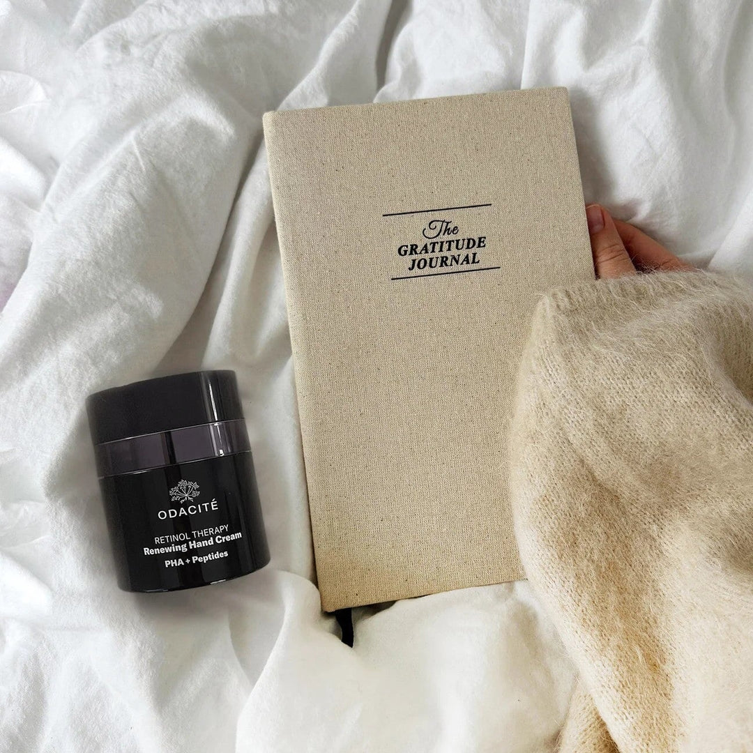 Odacité Retinol Handcreme auf der Bettdecke mit einem Journal – regenerierende Nachtpflege für trockene, reife Hände North Glow
