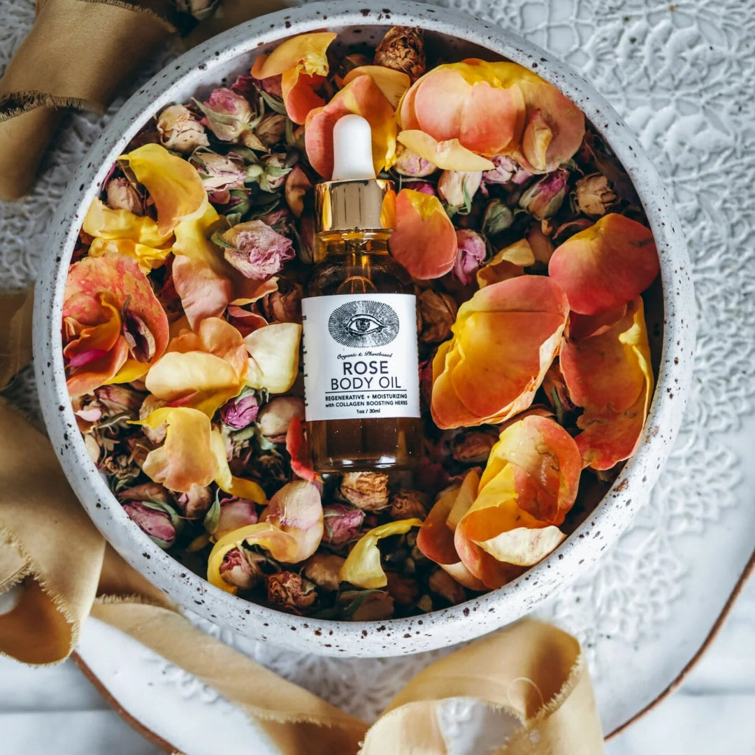 Rose Body Oil mit getrockneten Rosenblättern und pflanzlichen Wirkstoffen arrangiert North Glow