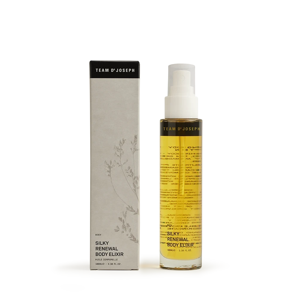 Team Dr Joseph Silky Renewal Body Elixir – elegantes Körperpflegeöl in schlanker Glasflasche mit Pumpspender, neben hochwertiger Umverpackung in Naturtönen, auf hellem Hintergrund.