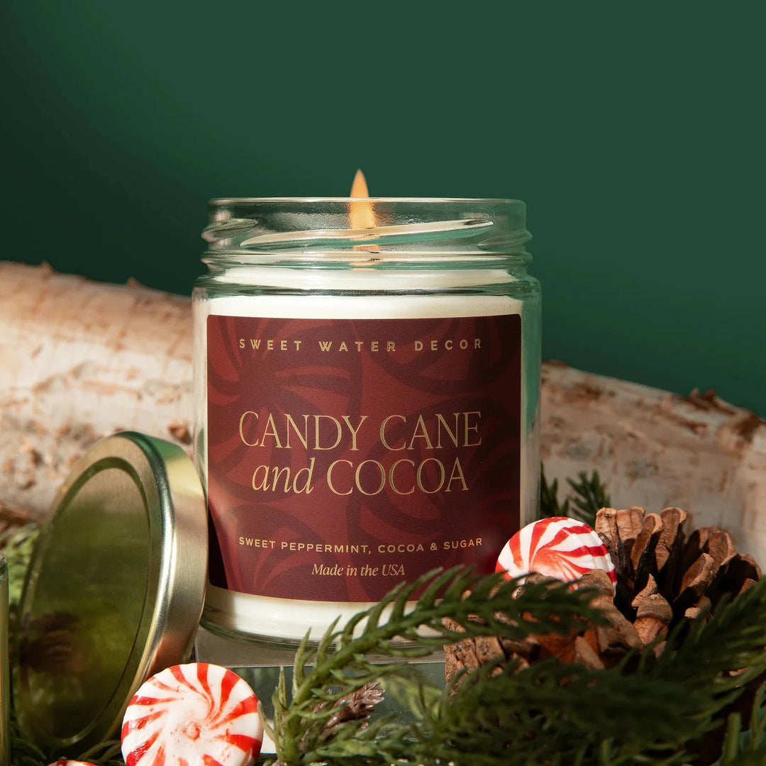 Brennende Duftkerze Candy Cane and Cocoa im Glas geschmückt mit Tannenzweigen und Zuckerstangenl.