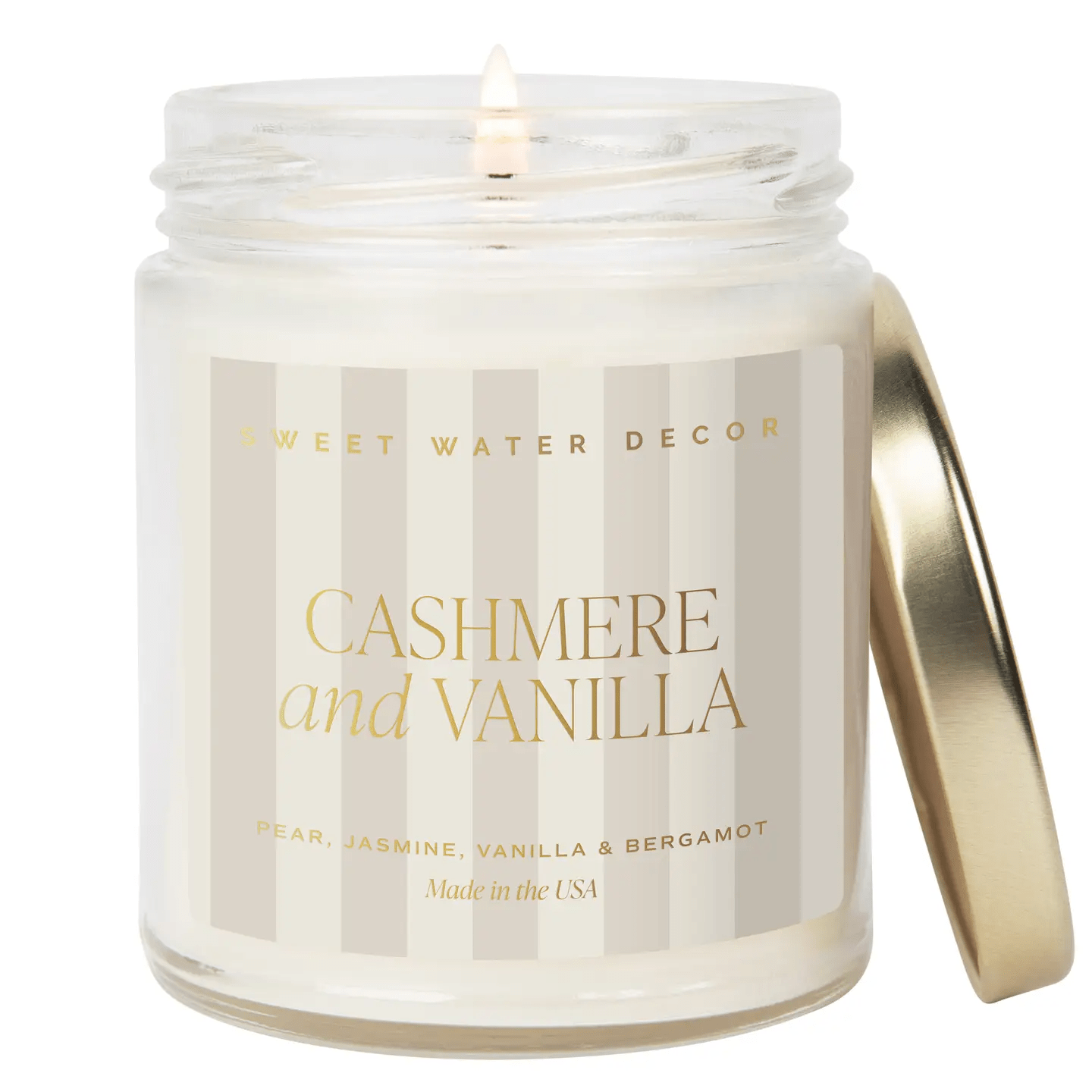 Brennende Sojawachskerze Cashmere and Vanilla mit angelehntem, goldenen Deckel, steht vor weißem Hintergrund.