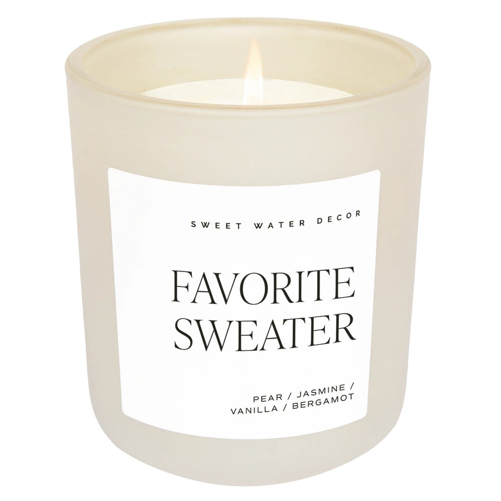 Brennende Duftkerze Favorite Sweater von Sweet Water Decor vor weißem Hintergrund.