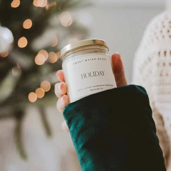Sweet Water Decor Kerze Holiday vor weihnachtlichen Hintergrund