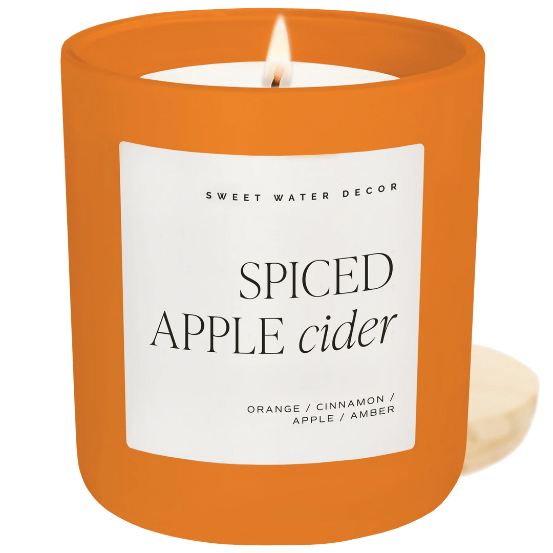 Brennende Spiced Apple Rider Sojawachskerze von Sweet Water Decor vor weißem Hintergrund North Glow