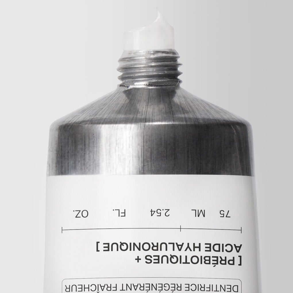 Nahaufnahmder einer the smilist Zahnpastatube über Kopf mit austretender Zahnpasta.